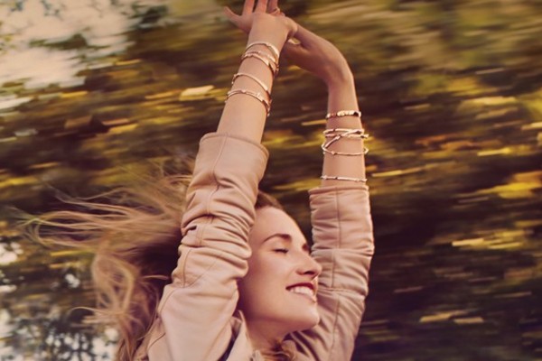 Woman wearing multiple Hearts On Fire bracelets with her arms raised in the air and eyes closed as she’s driving down the road and she’s through the sunroof. Woman wearing multiple Hearts On Fire bracelets with her arms raised in the air and eyes closed as she’s driving down the road and she’s through the sunroof.